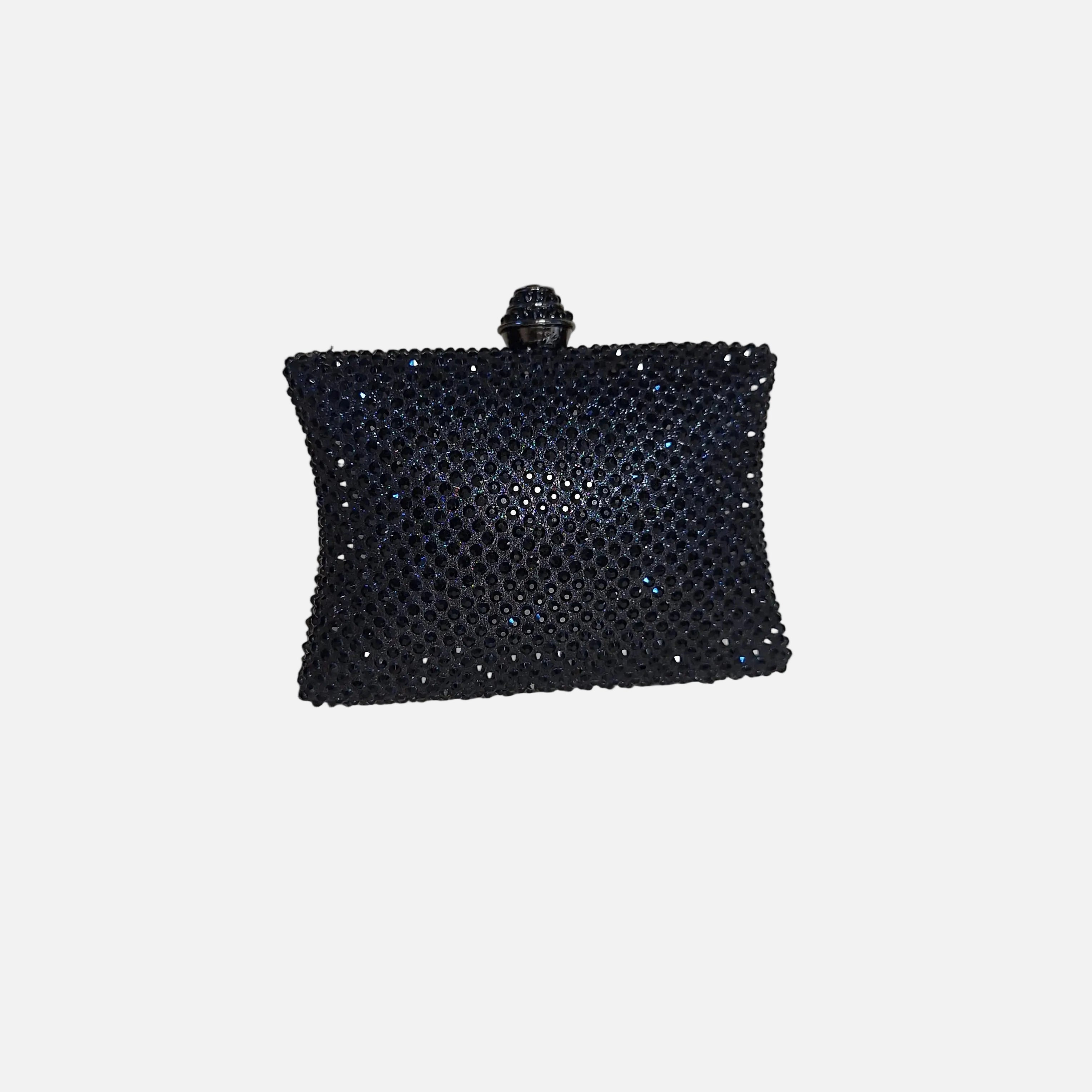 Black beaded clutch on a white surface with a neutral background